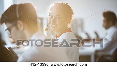 Stock Photograph - Businesswoman wearing headset in office. Fotosearch