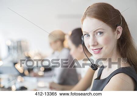 Businesswoman wearing headset in office View Large Photo Image Stock Photography - Businesswoman wearing headset in office. Fotosearch