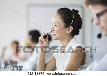 Stock Photography - Businesswoman wearing headset in office. Fotosearch