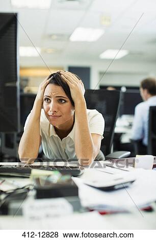 Stock Photo - Businesswoman working at desk in office. Fotosearch