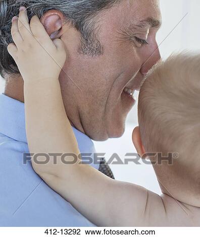 Close up of baby grabbing father's ear View Large Photo Image Stock Image - Close up of baby grabbing father's ear. Fotosearch