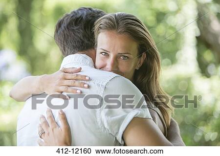 Stock Image - Couple hugging outdoors. Fotosearch