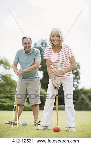 Stock Image - Couple playing croquet. Fotosearch