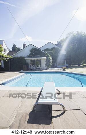 Diving board at edge of swimming pool View Large Photo Image Stock Photo - Diving board at edge of swimming pool. Fotosearch