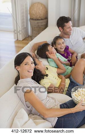 Family laughing on sofa in living room View Large Photo Image Stock Image - Family laughing on sofa in living room. Fotosearch