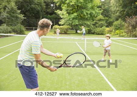 Family playing tennis on grass court View Large Photo Image Stock Photo - Family playing tennis on grass court. Fotosearch
