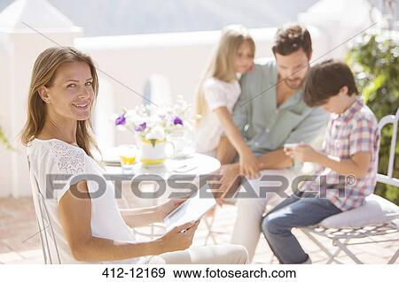 Stock Photo - Family relaxing on patio. Fotosearch