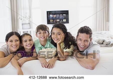 Stock Photo - Family relaxing together on sofa in living room. Fotosearch