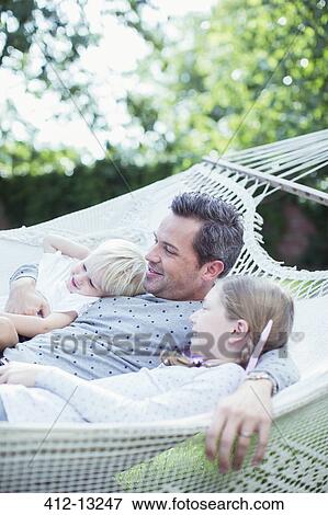 Stock Photo - Father and children relaxing in hammock. Fotosearch