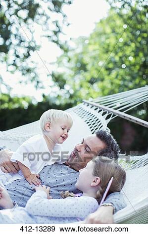 Stock Photo - Father and children relaxing in hammock. Fotosearch