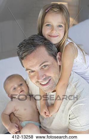 Father and children relaxing on bed View Large Photo Image Stock Photo - Father and children relaxing on bed. Fotosearch