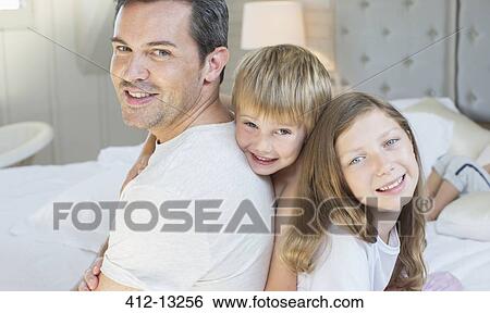 Father and children relaxing on bed View Large Photo Image Stock Photograph - Father and children relaxing on bed. Fotosearch