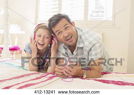 Father and daughter listening to headphones View Large Photo Image Stock Image - Father and daughter listening to headphones. Fotosearch