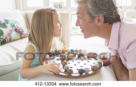 Picture - Father and daughter playing Chinese checkers. Fotosearch