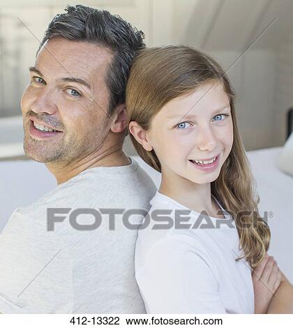 Stock Image - Father and daughter smiling in bedroom. Fotosearch