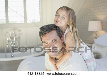 Stock Photography - Father and daughter smiling in bedroom. Fotosearch