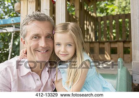 Stock Photo - Father and daughter smiling on playset. Fotosearch