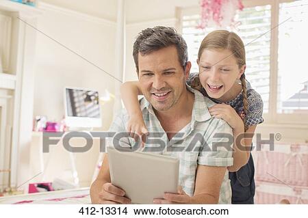 Picture - Father and daughter using digital tablet. Fotosearch