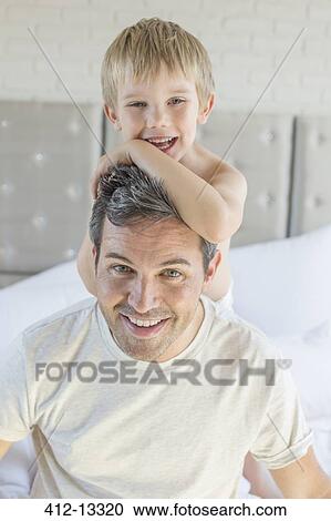 Father and son hugging on bed View Large Photo Image Stock Image - Father and son hugging on bed. Fotosearch