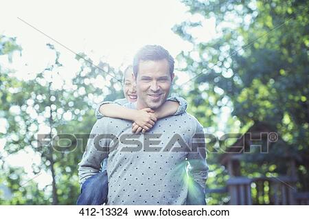 Father carrying daughter piggyback outdoors View Large Photo Image Picture - Father carrying daughter piggyback outdoors. Fotosearch