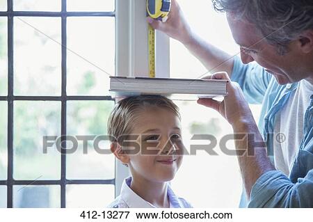 Father measuring son's height on wall View Large Photo Image Stock Photo - Father measuring son's height on wall. Fotosearch