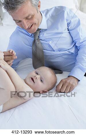 Father playing with baby on bed View Large Photo Image Stock Image - Father playing with baby on bed. Fotosearch