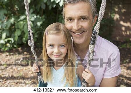 Stock Photo - Father pushing daughter on swing. Fotosearch