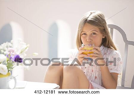 Girl drinking juice at table outdoors View Large Photo Image Stock Image - Girl drinking juice at table outdoors. Fotosearch