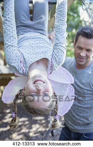 Girl hanging from monkey bars outdoors View Large Photo Image Stock Image - Girl hanging from monkey bars outdoors. Fotosearch