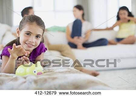 Stock Photo - Girl putting coins in piggy bank. Fotosearch