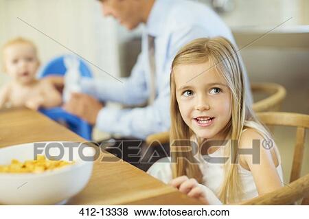 Stock Photo - Girl sitting at breakfast table. Fotosearch