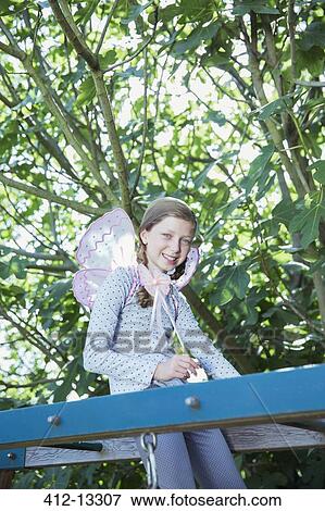 Stock Photo - Girl smiling on monkey bars outdoors. Fotosearch