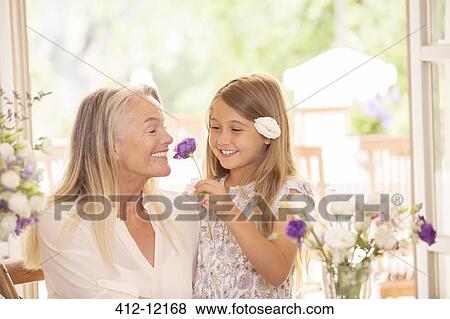 Grandmother and granddaughter smelling flowers View Large Photo Image Stock Photo - Grandmother and granddaughter smelling flowers. Fotosearch