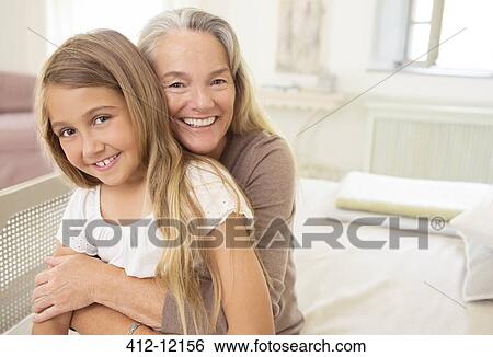 Grandmother hugging granddaughter View Large Photo Image Stock Photograph - Grandmother hugging granddaughter. Fotosearch
