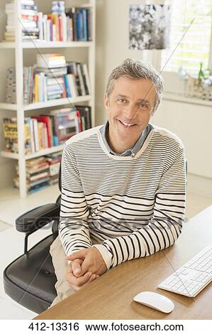 Man smiling at computer desk View Large Photo Image Stock Photograph - Man smiling at computer desk. Fotosearch