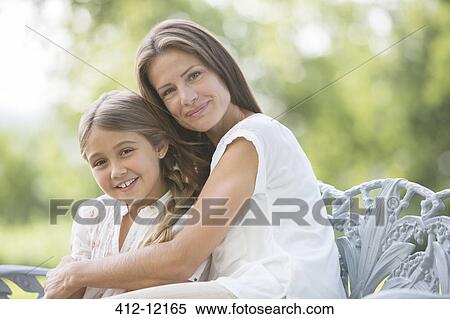 Stock Photography - Mother and daughter hugging outdoors. Fotosearch