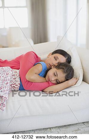 Mother and daughter napping on sofa in living room View Large Photo Image Stock Image - Mother and daughter napping on sofa in living room. Fotosearch