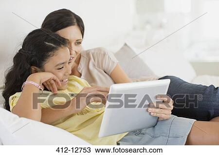 Mother and daughter using digital tablet on bed View Large Photo Image Stock Image - Mother and daughter using digital tablet on bed. Fotosearch