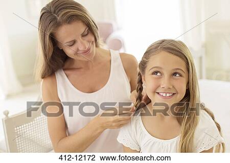 Mother braiding daughter's hair View Large Photo Image Stock Image - Mother braiding daughter's hair. Fotosearch