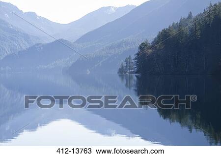 Mountains reflected in calm lake View Large Photo Image Stock Image - Mountains reflected in calm lake. Fotosearch