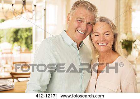 Stock Image - Older couple smiling indoors. Fotosearch