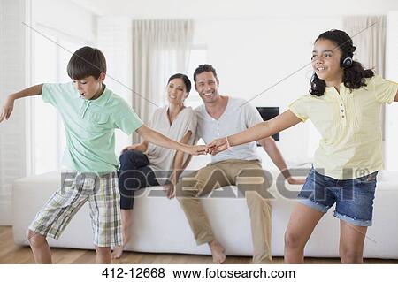 Parents watching daughter and son dancing in living room View Large Photo Image Stock Photo - Parents watching daughter and son dancing in living room. Fotosearch