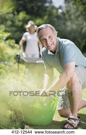 Picture - Senior couple working in garden. Fotosearch
