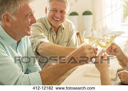Stock Image - Senior friends toasting wine glasses. Fotosearch