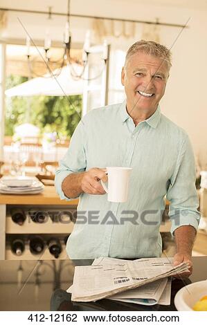 Senior man drinking coffee and reading newspaper in kitchen View Large Photo Image Stock Image - Senior man drinking coffee and reading newspaper in kitchen. Fotosearch