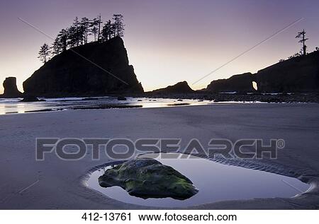 Silhouette of cliffs on beach at low tide View Large Photo Image Stock Image - Silhouette of cliffs on beach at low tide. Fotosearch