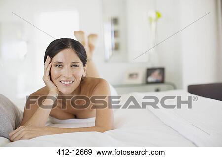Smiling woman laying on bed View Large Photo Image Stock Photo - Smiling woman laying on bed. Fotosearch