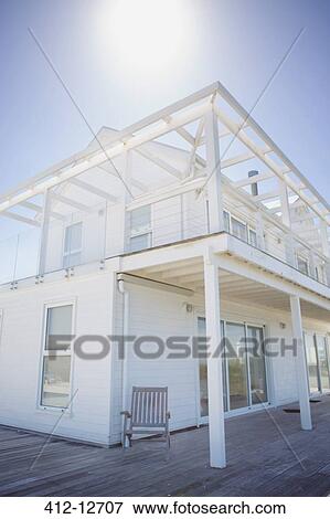Stock Photo - Sun shining over white house. Fotosearch