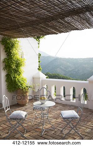 Table and chairs on balcony overlooking mountain View Large Photo Image Stock Photography - Table and chairs on balcony overlooking mountain. Fotosearch