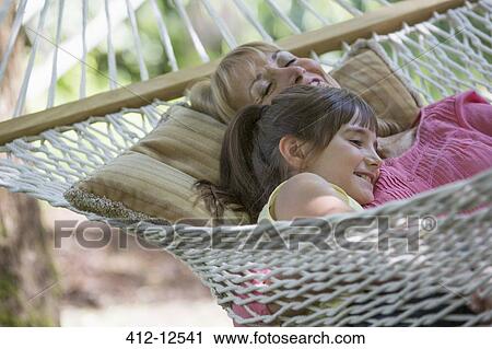 Stock Image - Woman and granddaughter relaxing in hammock. Fotosearch